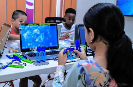 Kinder sitzen vor einem Laptop und tütfteln mit digitalen Tools. 